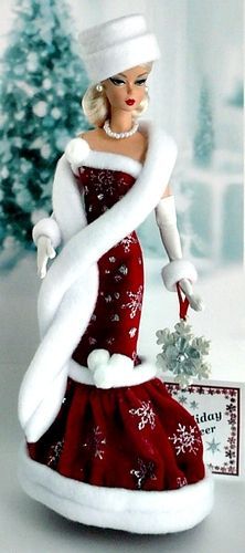 a christmas ornament with a woman in a red dress and white hat on it