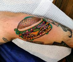 a man with a hamburger tattoo on his arm