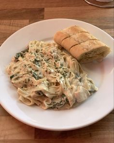 a white plate topped with pasta and bread