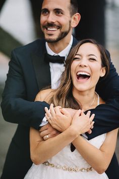 a man in a tuxedo is hugging a woman