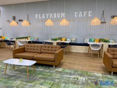 a room with couches, chairs and tables inside of it that says playroom cafe