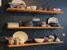 two wooden shelves filled with plates and bowls