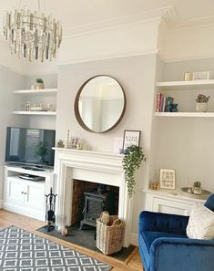 a living room filled with furniture and a flat screen tv mounted to a wall next to a fire place