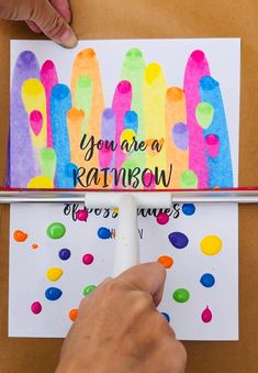 someone is making a rainbow card with crayons