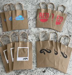 brown paper bags with red and black images on them sitting on a counter top next to each other