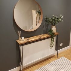 there is a mirror on the wall next to a radiator and some plants