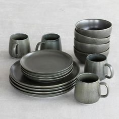 a set of gray dishes and cups on a table