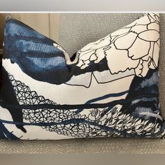 a blue and white pillow sitting on top of a couch