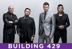 a group of men standing next to each other in front of a building 429 sign