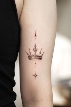 a woman's arm with a crown tattoo on the left side of her arm