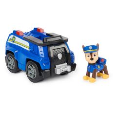 a toy police car next to a small plastic dog figurine on a white background