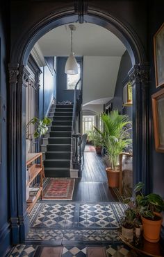 an entry way with stairs and potted plants