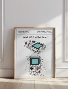 an old video game poster hanging on the wall next to a wooden frame with a drawing of a hand held video game