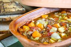 a bowl filled with soup next to some bread