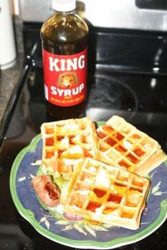 a plate with waffles and syrup on top of the counter next to an oven