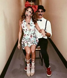 a man and woman sitting on a chair in the hallway with fake makeup painted on their faces