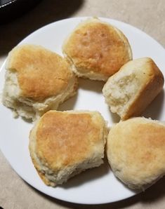 four biscuits sitting on top of a white plate