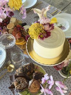 a table topped with lots of different types of food and flowers on top of it