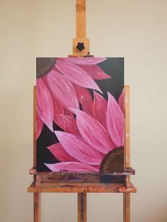 an easel with a pink flower painted on it