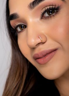 a close up of a woman's face with eyeliner and eyelashes on her nose