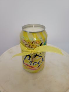 a can of lemonade sitting on top of a table next to a yellow ribbon