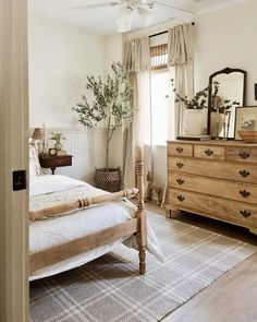 a bedroom with a bed, dresser and mirror