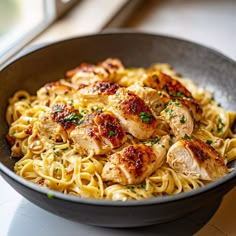 pasta with chicken and parsley in a black bowl