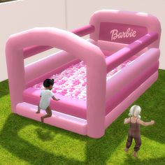 an inflatable ball pit with two children playing inside and on the ground next to it