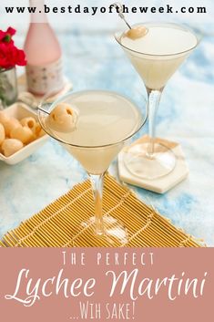 two martinis sitting next to each other on a blue table cloth with flowers in the background