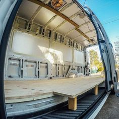 the back end of an empty vehicle with wood planks on the floor and windows