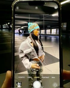 a person holding up a cell phone with an image of a woman on the screen