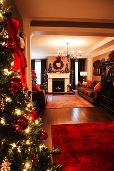 a living room decorated for christmas with red and gold decorations