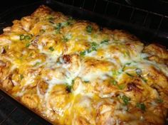 a casserole dish with chicken and cheese in the oven, ready to be baked