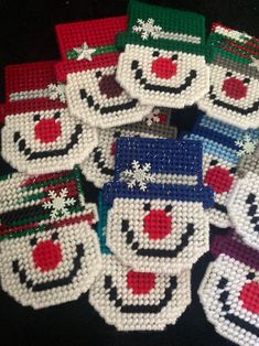 a group of knitted snowman coasters sitting on top of a black table