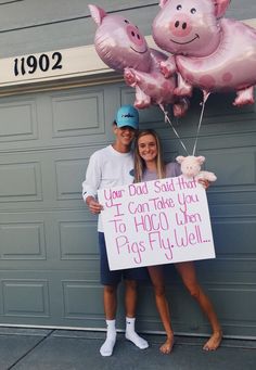 two people standing in front of a garage holding up pink pig balloons and a sign that says, your god said that you can take you to hoo when pigs fly