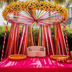 a bed with sunflowers on it in the middle of a canopy decorated with ribbons and flowers