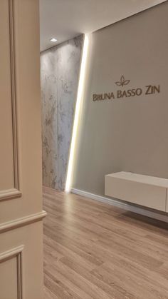 an empty room with wooden floors and a white cabinet in the corner that says bruna basso zin