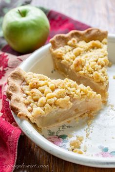 two pieces of pie on a plate next to an apple