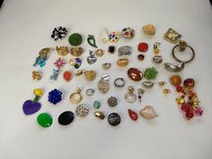 a collection of various rings and pendants on a white surface