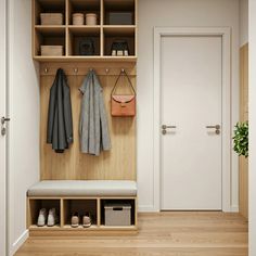 a wooden bench sitting under a coat rack next to a white door with two coats hanging on it