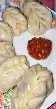 some dumplings are on a plate with sauce