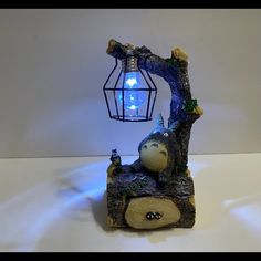 a small light bulb sitting on top of a tree stump next to a caged lantern