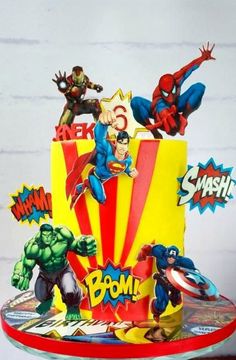 a birthday cake decorated with superheros and stars