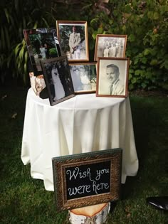 a table topped with pictures and framed photos next to a sign that says wish you were here