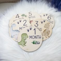 four wooden baby's first month coasters on a white furnishing area