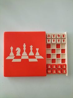 a set of chess pieces on a red board and some rubber stamps with white squares