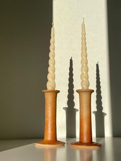 three candles sitting on top of a table next to each other