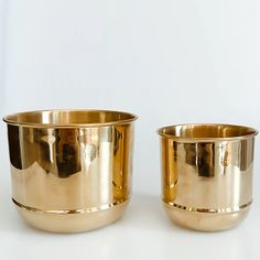 two shiny metal bowls sitting next to each other