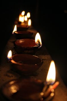 lit candles are lined up in a row