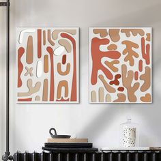 two abstract paintings hang on the wall above a radiator